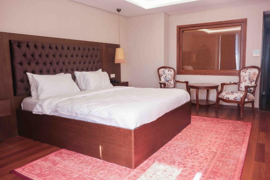 a bedroom with a large bed and a table and chairs at Phellos Suites Boutique Hotel in Şile