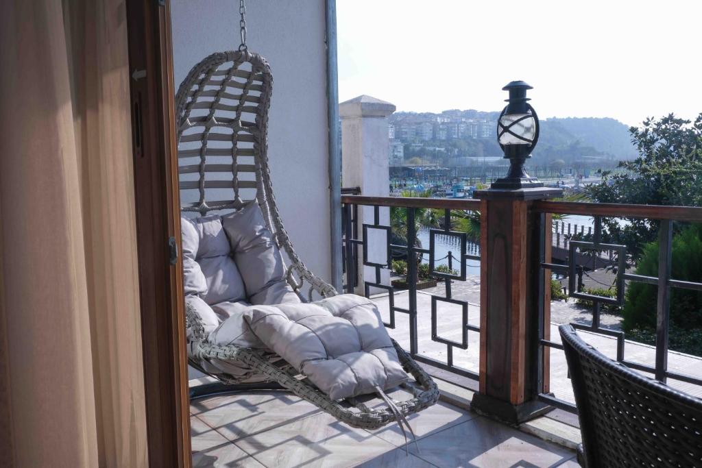 a swinging chair on a balcony with a view at Phellos Suites Boutique Hotel in Şile