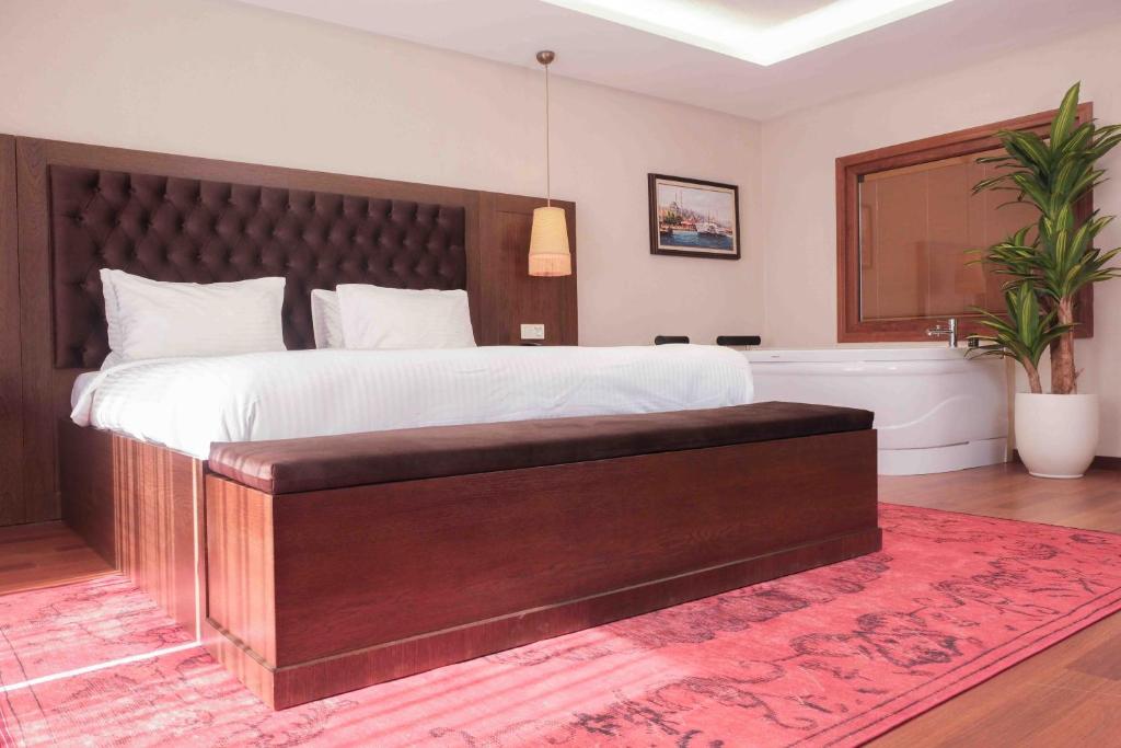 a bedroom with a large bed with a large wooden headboard at Phellos Suites Boutique Hotel in Şile