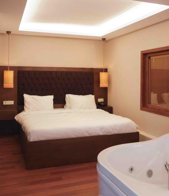 a bedroom with a large bed and a bath tub at Phellos Suites Boutique Hotel in Şile