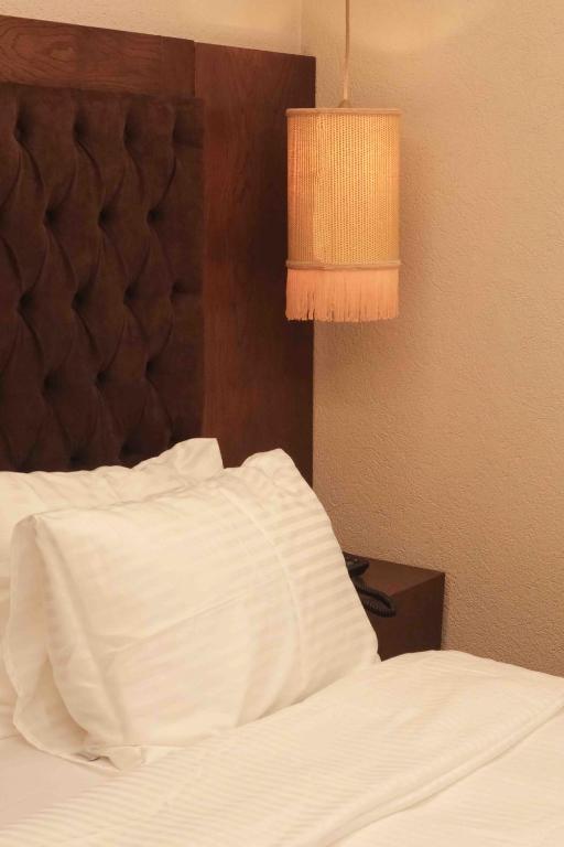 a bedroom with a white bed and a lamp at Phellos Suites Boutique Hotel in Şile
