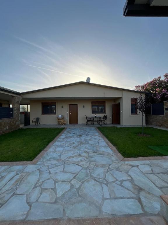 a house with a stone driveway in front of it at Victoria's Apartments in Néa Tríglia