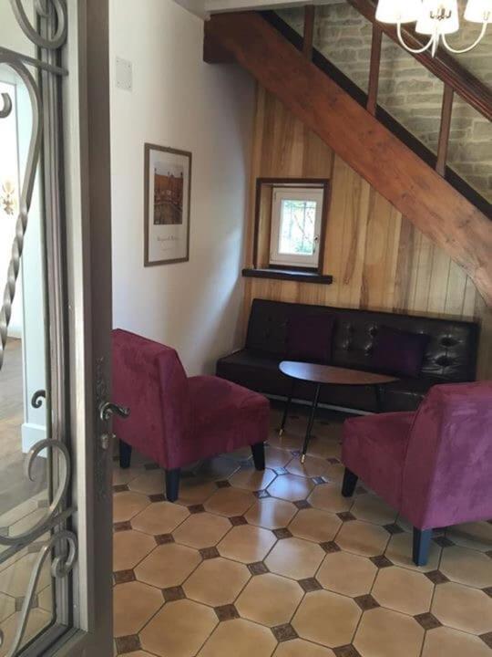 un salon avec des chaises rouges et une table dans l'établissement Belle maison au coeur de Beaune avec piscine privée, Cabotte Dionysos, à Beaune