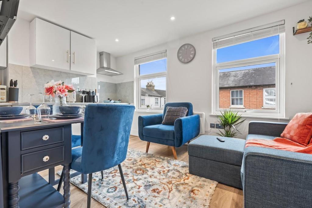 a kitchen and living room with blue chairs and a table at 2 Bedroom flat for Corporate, workers, Relocation, West st in Buckinghamshire