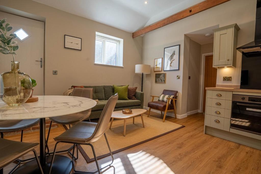 un salon avec une table et un canapé dans l'établissement Dunes Cottage, à Lowestoft