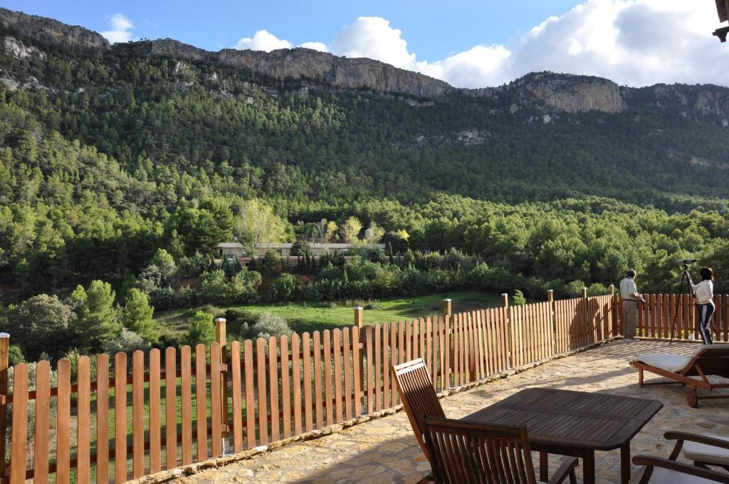 a wooden fence with a table and chairs on a patio at Observatorio de Aves Mas de Bunyol in Valderrobres