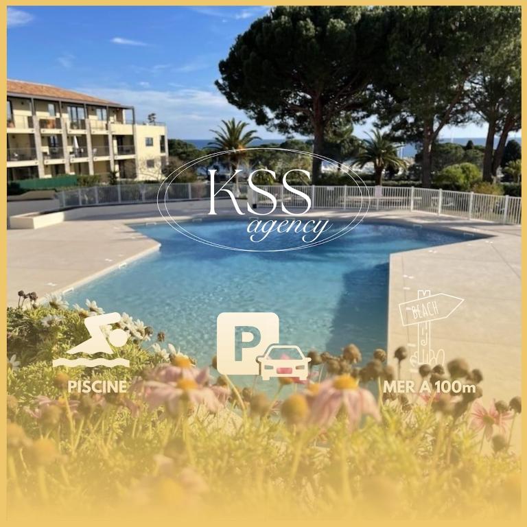 une photo d'une piscine en face d'un bâtiment dans l'établissement Appt 27m2 - parking - clim - piscine - mer à 100m, à Roquebrune-sur Argens