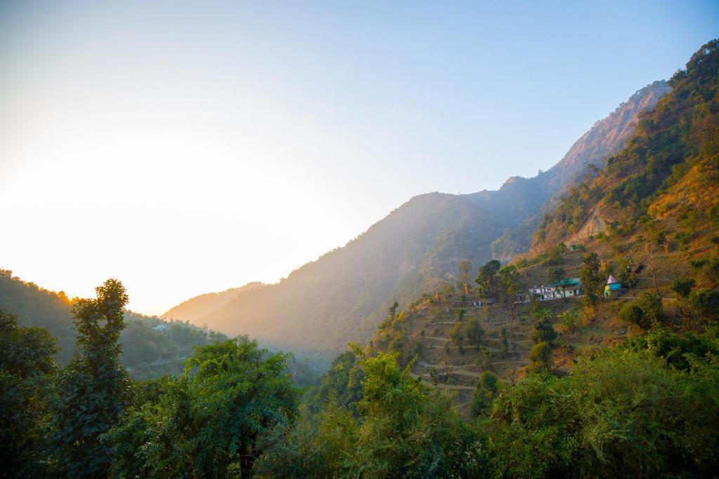 une vue d'une montagne avec des arbres et des maisons dessus dans l'établissement Alaya Stays Madhuram Villa - Pet-Friendly 5 BHK Hillside Retreat With Garden & Balcony, à Dhanaulti
