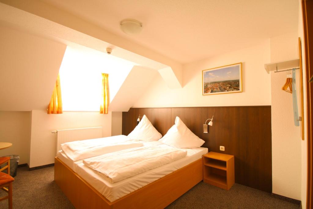 a bedroom with a large bed with a large window at Pension bei der Marienkirche in Mühlhausen