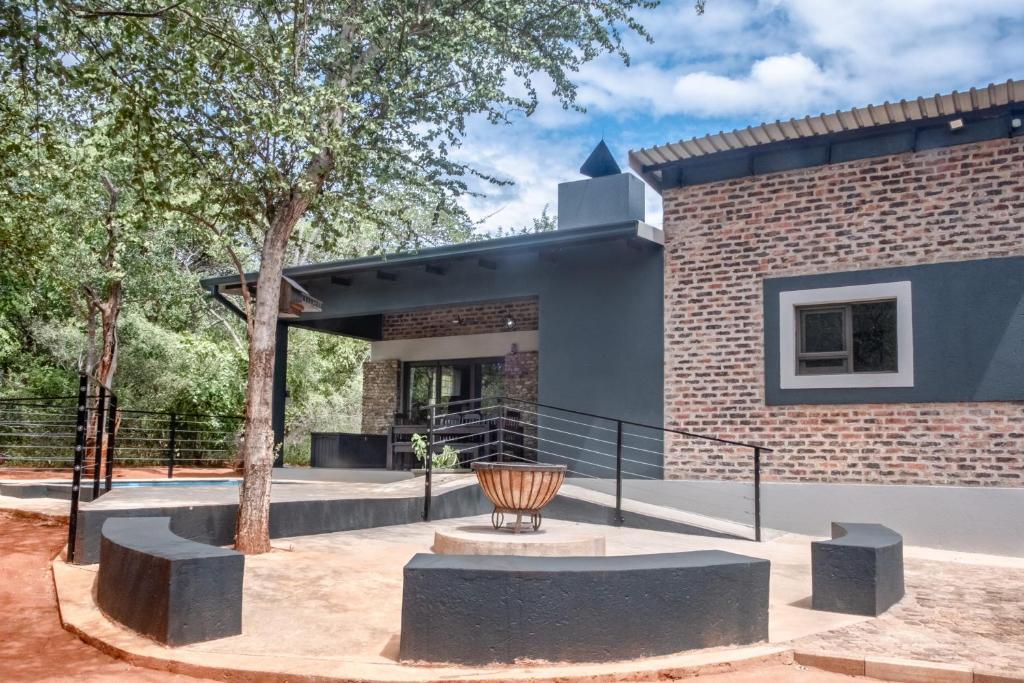 a brick building with a tree in front of it at Die Watergat in Marloth Park