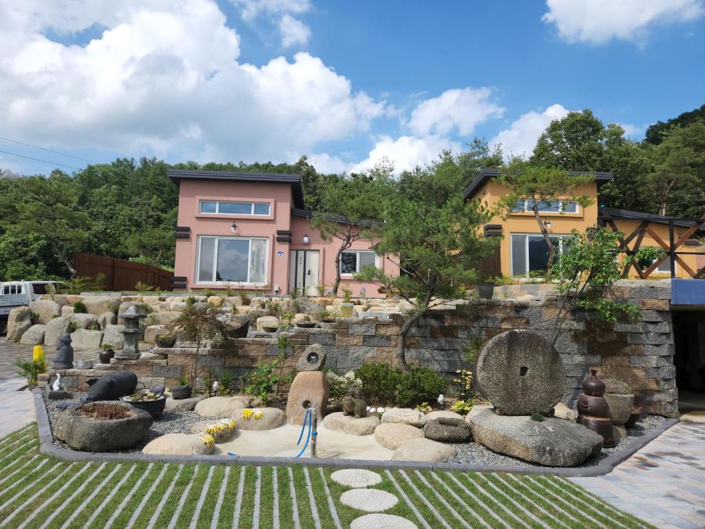 a house with a garden in front of it at 비우리게스트하우스 in Kujŏm