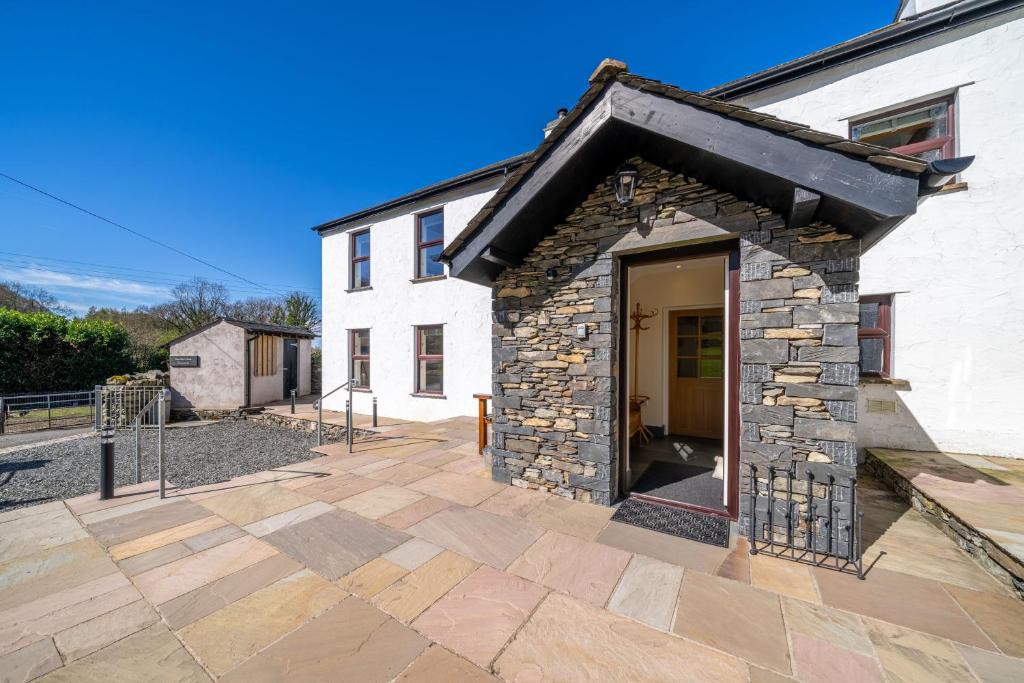 a stone building with a door in front of it at High Brow Edge Farm Cottage in Backbarrow