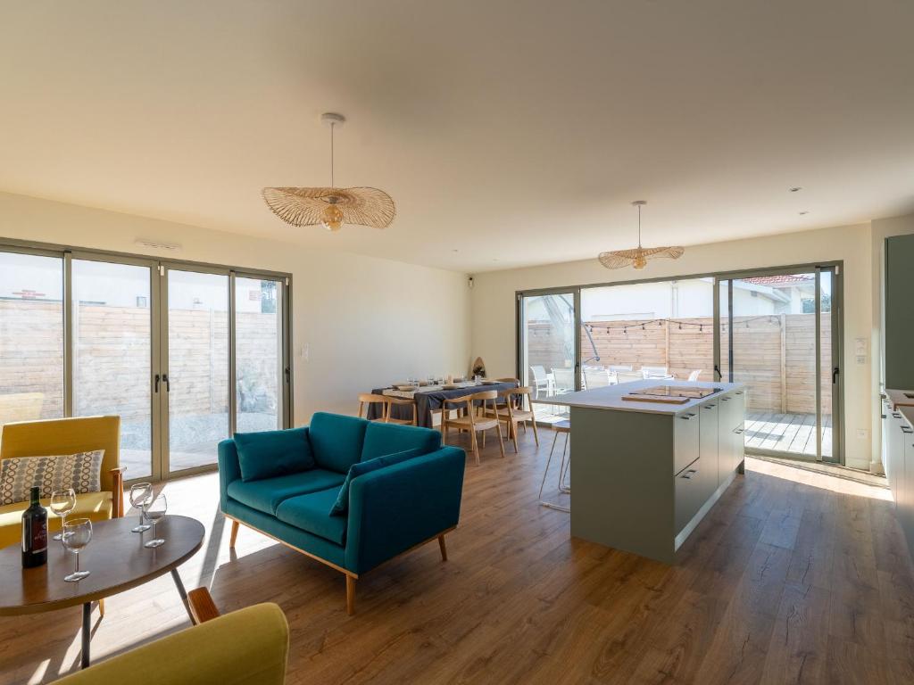 a living room with a blue couch and a table at Maison neuve proche océan, terrasse, parking, 8 pers - FR-1-319-585 in Biscarrosse