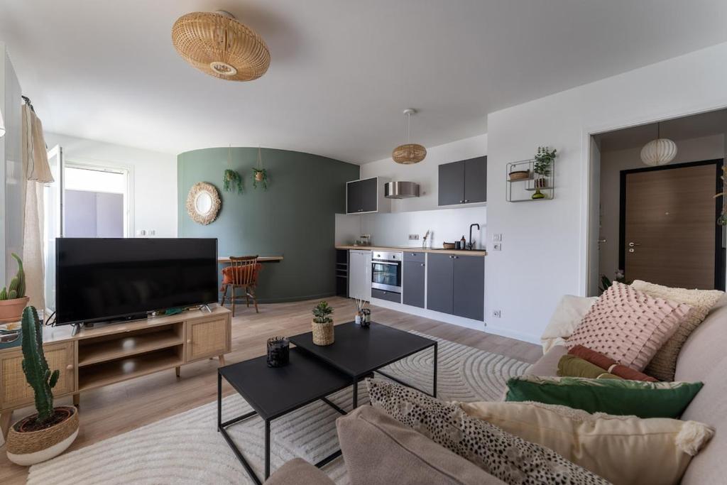 un salon avec un canapé et une télévision dans l'établissement Annecy, calme, terrasse, parking box, à Annecy