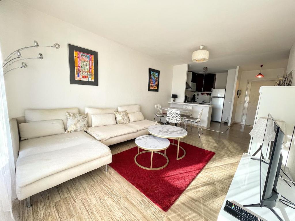 - un salon avec un canapé blanc et un tapis rouge dans l'établissement Serenity YourHostHelper, à Antibes