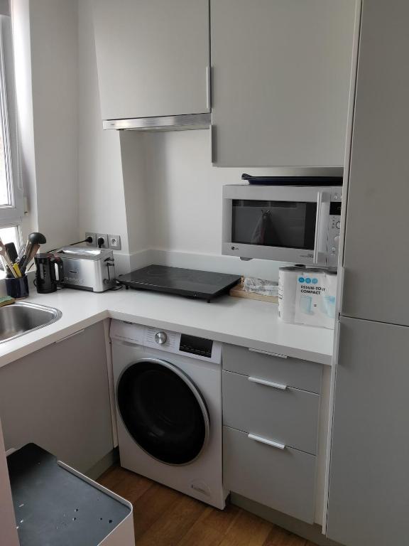 une cuisine avec un lave-linge et un micro-ondes dans l'établissement Père Corentin - CI - Bright apt for 2pers at Porte d'Orléans, 14è, à Paris
