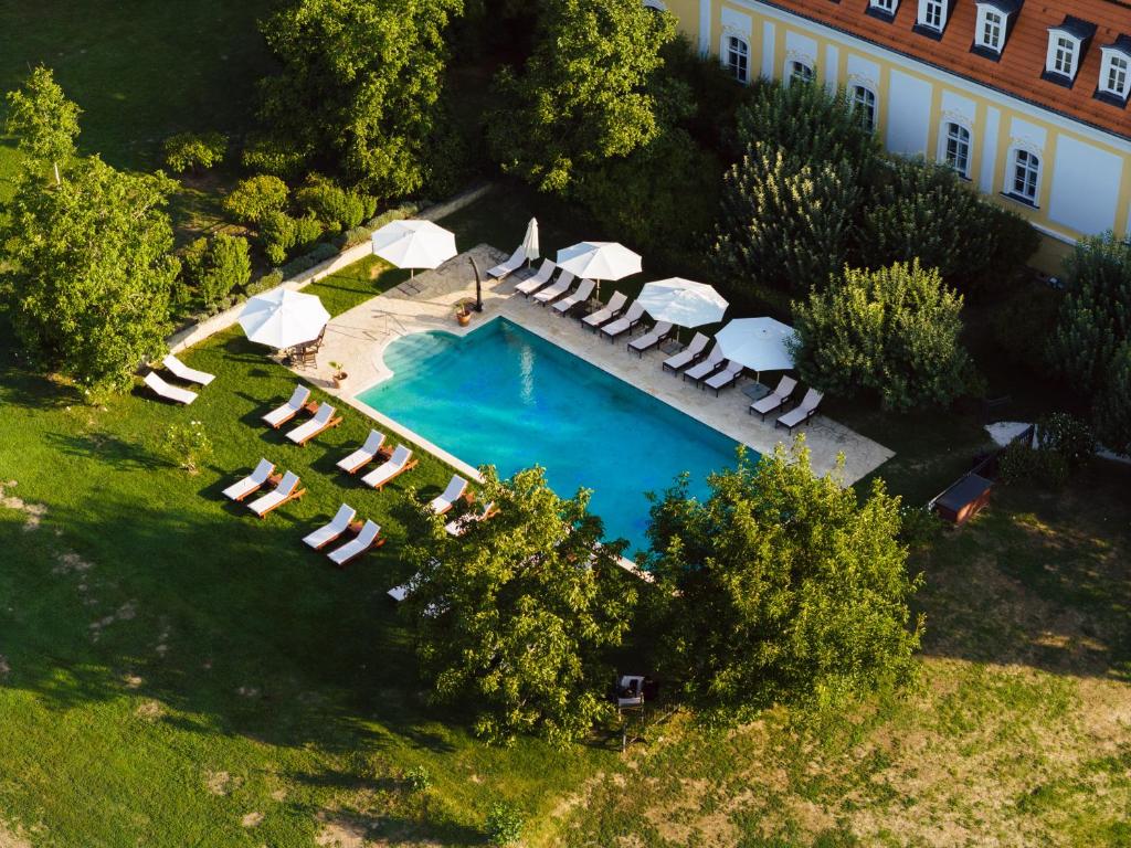 an aerial view of a swimming pool with chairs and umbrellas at Hotel Château Bela in Belá