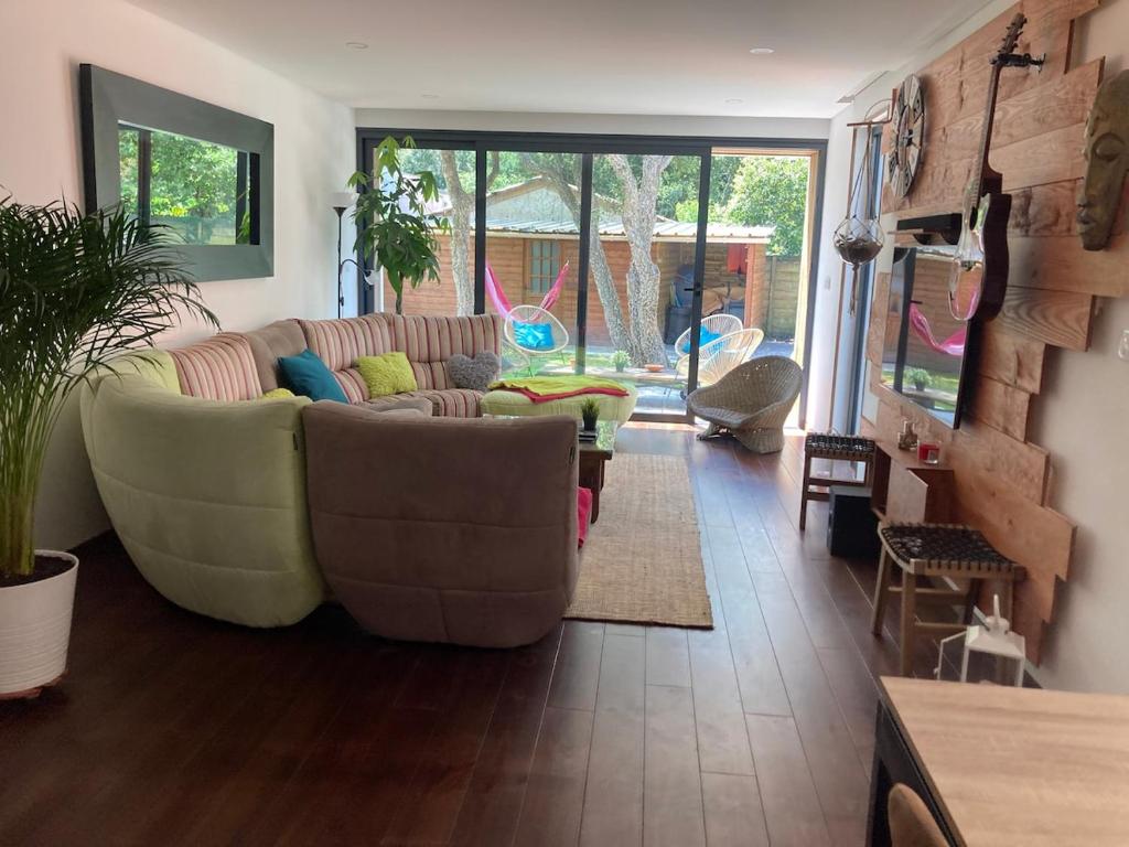 a living room with a couch and a table at Magnifique Maison architecturale à l'Océan in Labenne