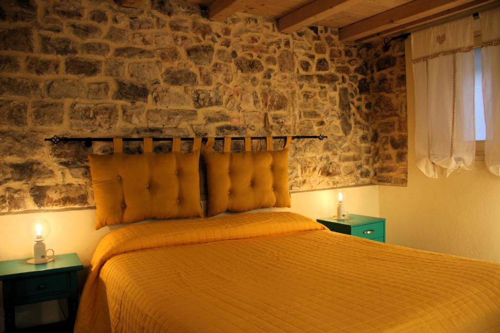 ein Schlafzimmer mit einem Bett mit zwei Nachttischen und zwei Lampen in der Unterkunft La Casa del Sole a Cosy Nest in Lunigiana, Tuscany in Giucano