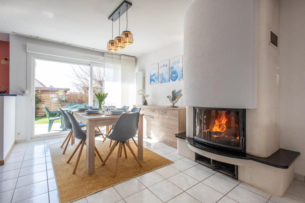 a living room with a fireplace and a table and chairs at La Maison Effet Mer - Proche plage, parking privé in Berck-sur-Mer