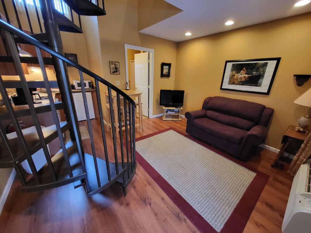 Una sala de estar con un sofá y una escalera. en Suites On Chocolate - The Theater, en Hershey