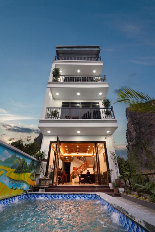 a house with a swimming pool in front of a building at Maison Tam Cốc Homestay in Vũ Lâm