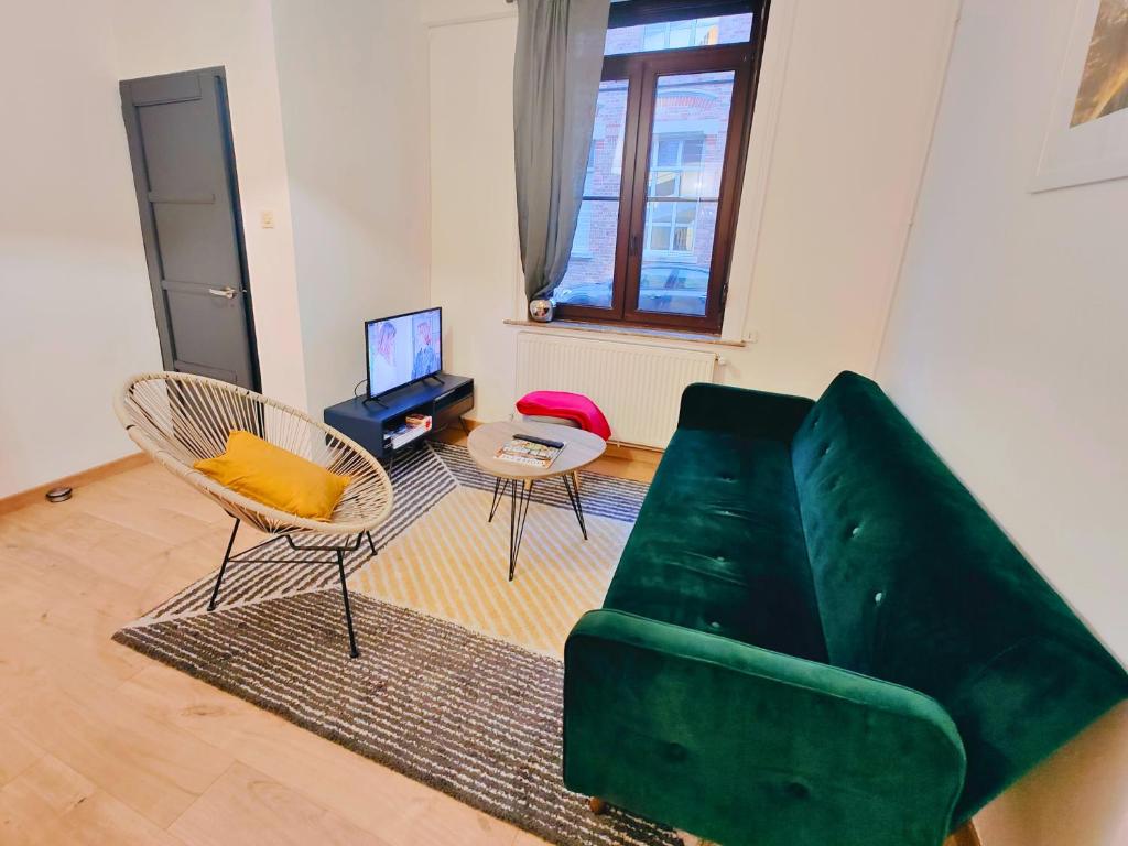 - un salon avec un canapé vert et 2 chaises dans l'établissement Maison familiale avec terrasse pour 7 personnes, à Lambersart
