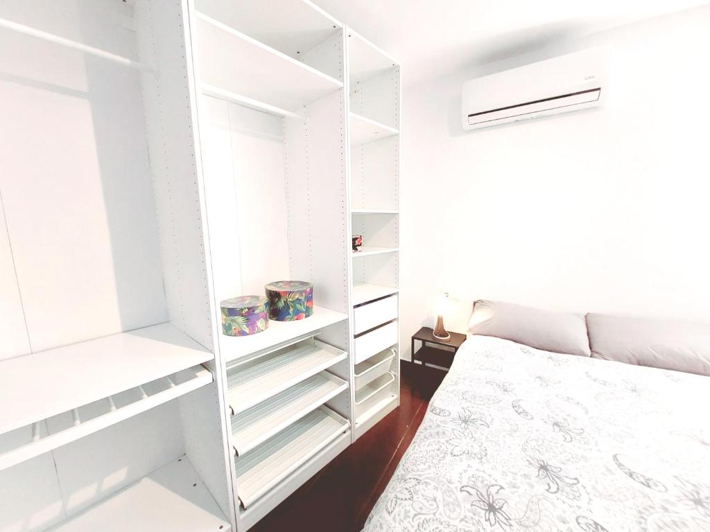 a bedroom with white shelves and a bed at Alojamiento Dream en Murcia centro in Murcia