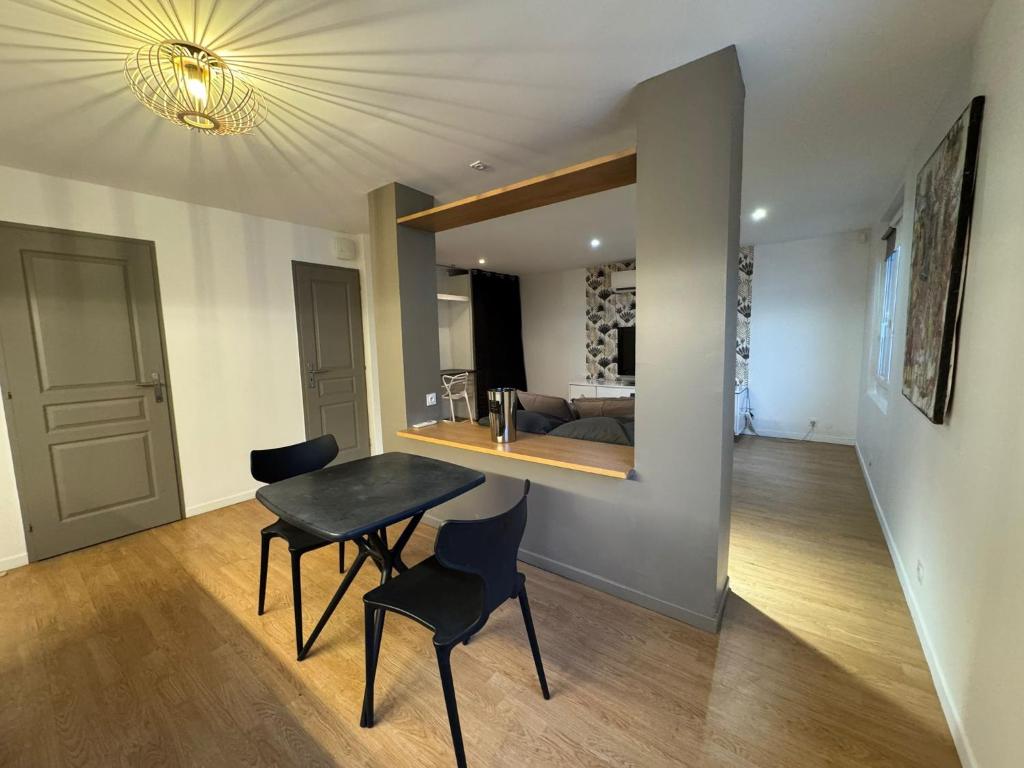 une pièce avec une table et des chaises et une chambre dans l'établissement 2 Twenty Fort Studio with pool Lyon, à Villeurbanne