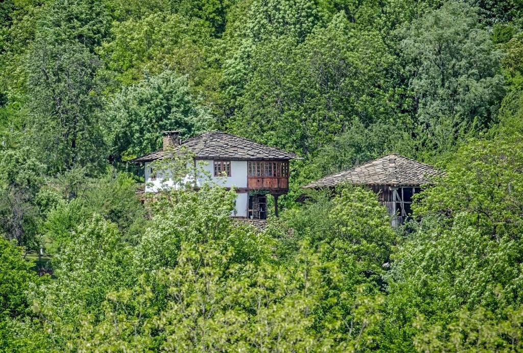 ein altes Haus mitten im Wald in der Unterkunft Incredible Cabin Getaway with Indoor and Outdoor Fireplaces in Selishte, Bulgaria in Karatsite