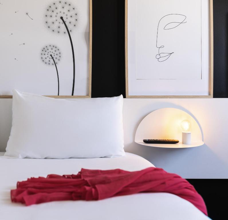 un lit avec une robe rouge assise au-dessus dans l'établissement ibis Styles Paris Gare de l'Est Château Landon, à Paris