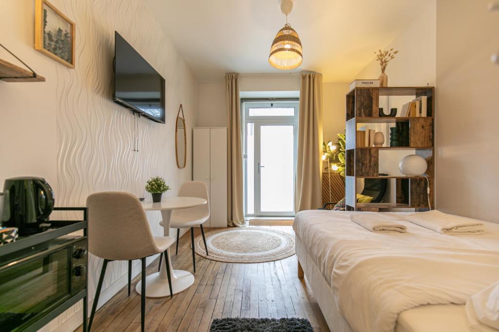 une chambre d'hôtel avec un lit, une table et des chaises dans l'établissement MBA - Splendide Apart Proche Bastille, à Paris