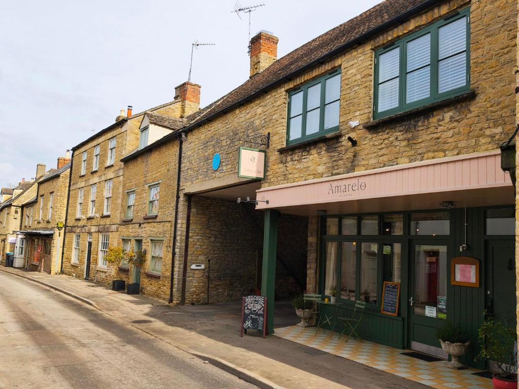 a row of brick buildings on a street at Amarelo apartment, Central Charlbury, 1 Super king bed in Charlbury