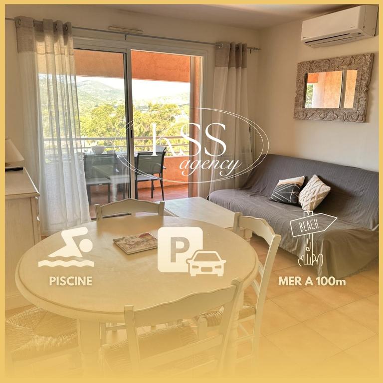 un salon avec une table et un canapé dans l'établissement Appt 2 étoiles - parking - clim - piscine - mer à 300m, à Roquebrune-sur Argens