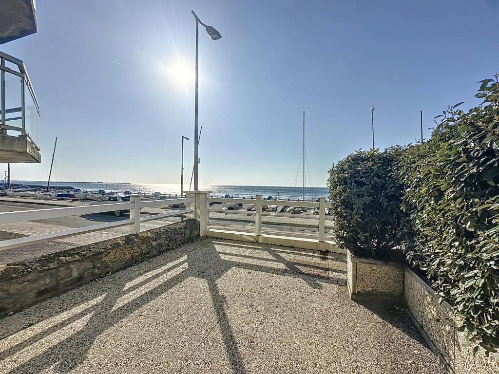 une clôture sur le côté d'une route à côté de l'océan dans l'établissement Saint Georges - duplex face mer, à Wimereux