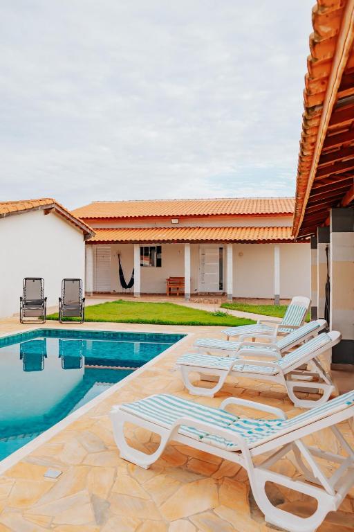 a group of lounge chairs next to a swimming pool at Chácara Recanto Lunar in Boituva