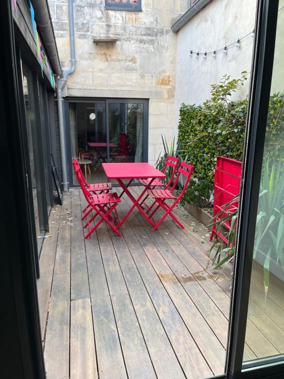 un tavolo rosso e sedie su una terrazza in legno di Grand duplex centre historique a La Rochelle