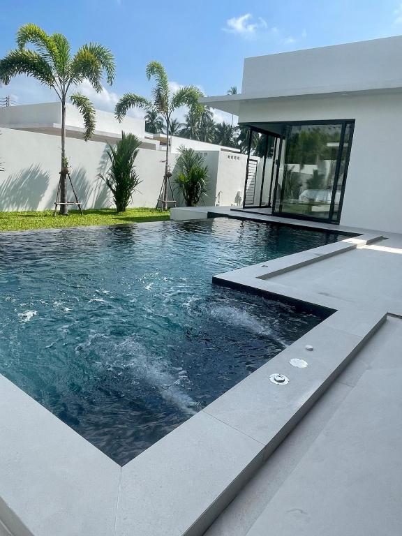 a swimming pool in front of a house at Villa Miss Elephant in Ban Thung