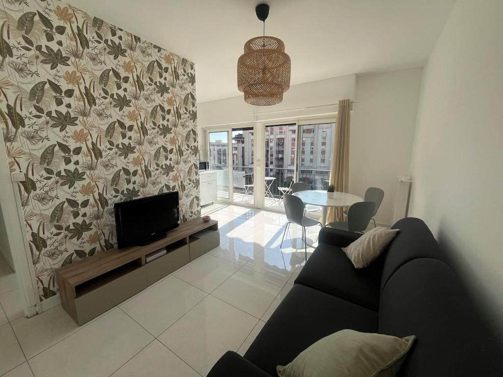 un salon avec un canapé, une télévision et une table dans l'établissement Scaliero T2 avec terrasse plein soleil, à Nice