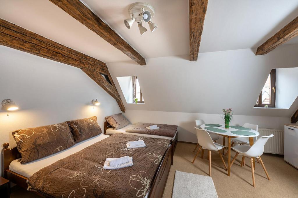 a bedroom with a bed and a table at Rodinný hotel Myslivna in Třeboň