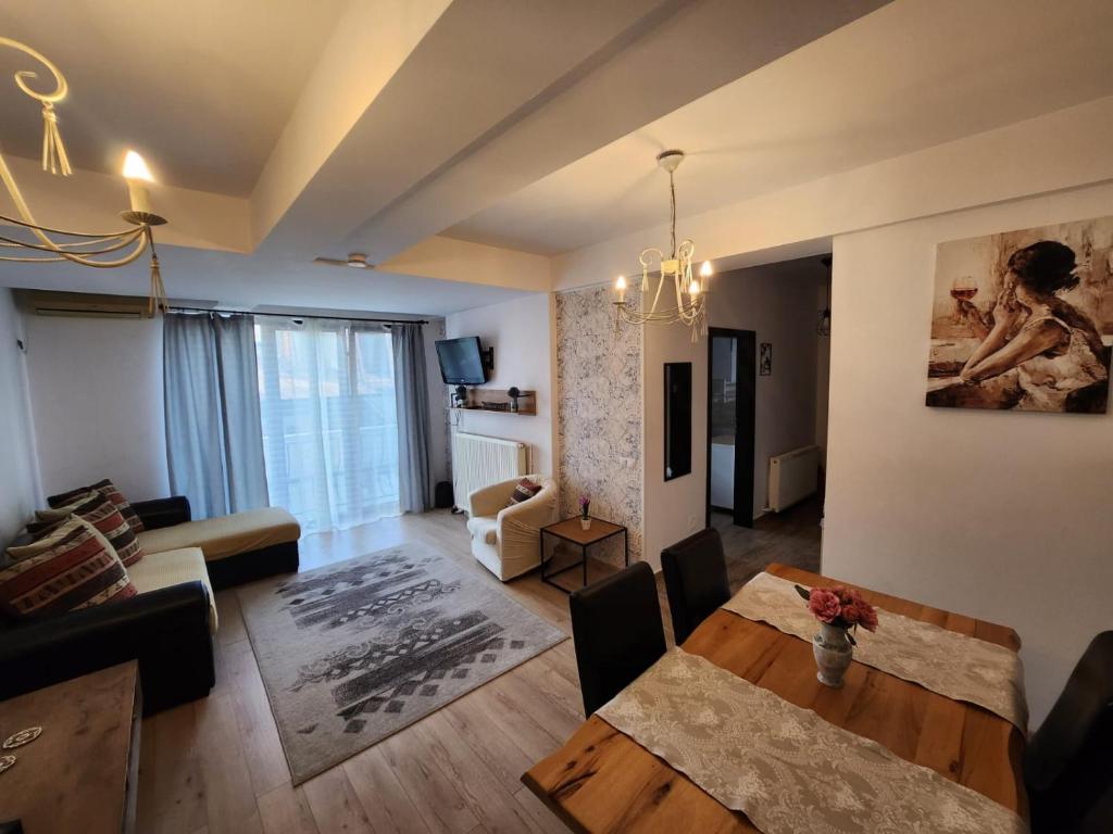 a living room with a table and a dining room at Morii Lake Apartment in Bucharest
