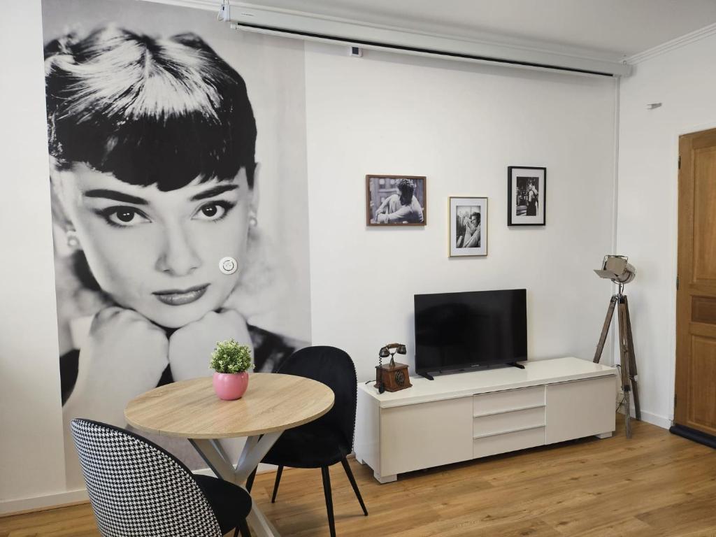 un soggiorno con murale di una donna di Le Cin et Chic Vidéoprojecteur Popcorn Netflix a Saint-Étienne