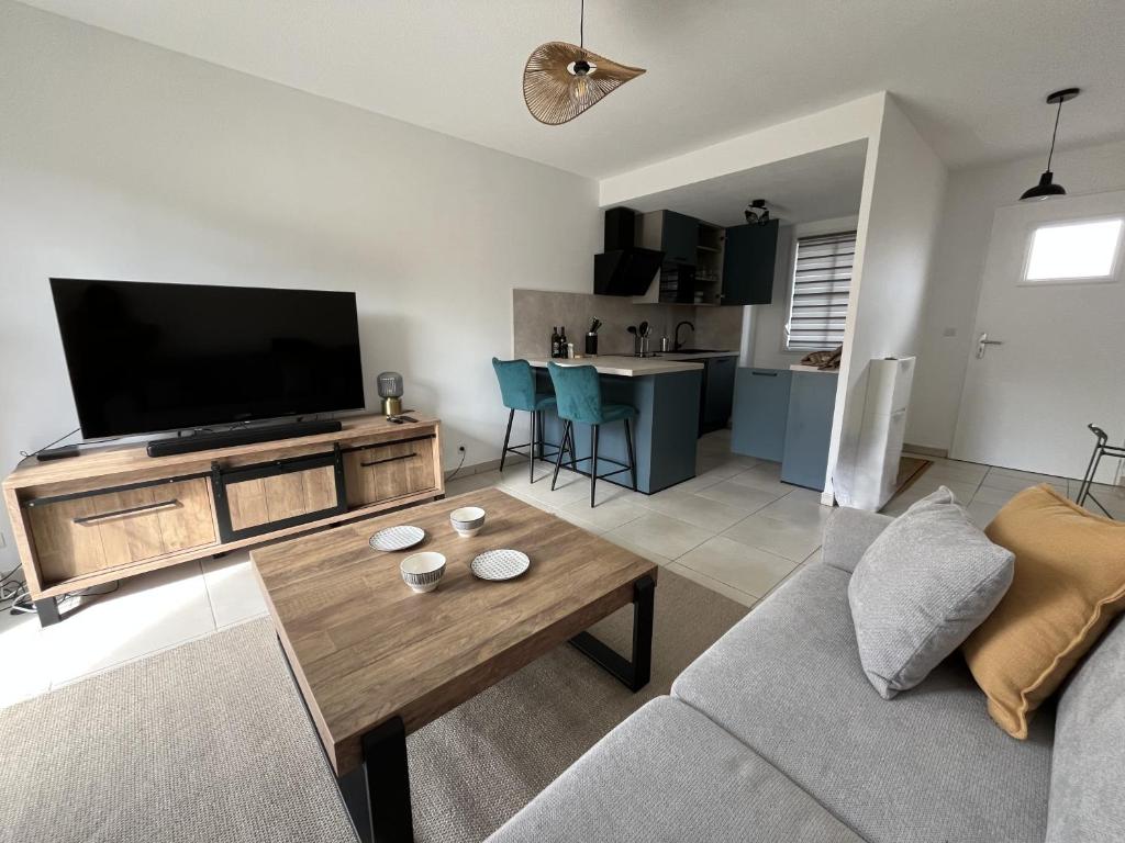 un salon avec un canapé et une télévision dans l'établissement Charmant T2 rénové avec balcon, proche plage et commerces, à Arès