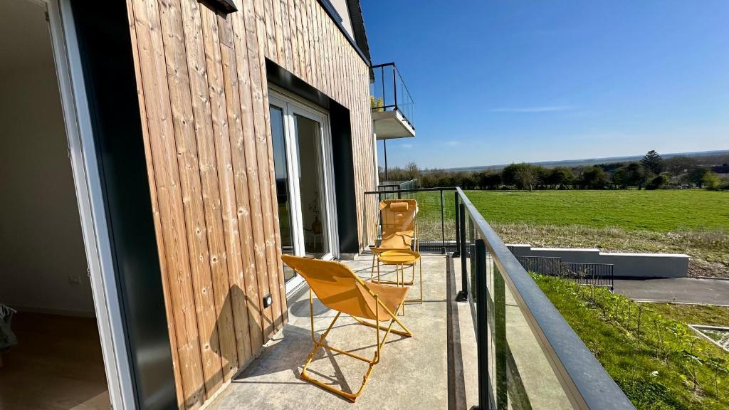 - deux chaises assises sur le balcon d'une maison dans l'établissement Henson, appartement pour 4 personnes, à Saint-Valery-sur-Somme