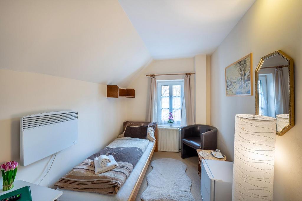 a small living room with a couch and a mirror at Rodinný hotel Myslivna in Třeboň