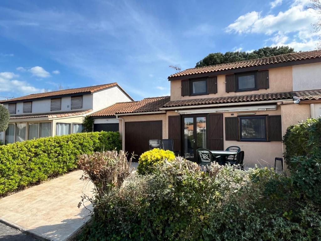 une maison avec une terrasse en face de celle-ci dans l'établissement Jolie Villa climatisée 5 couchages, Résidence LES TAMARIS, wifi, PORTIRAGNES PLAGE LRTAMB8, à Portiragnes
