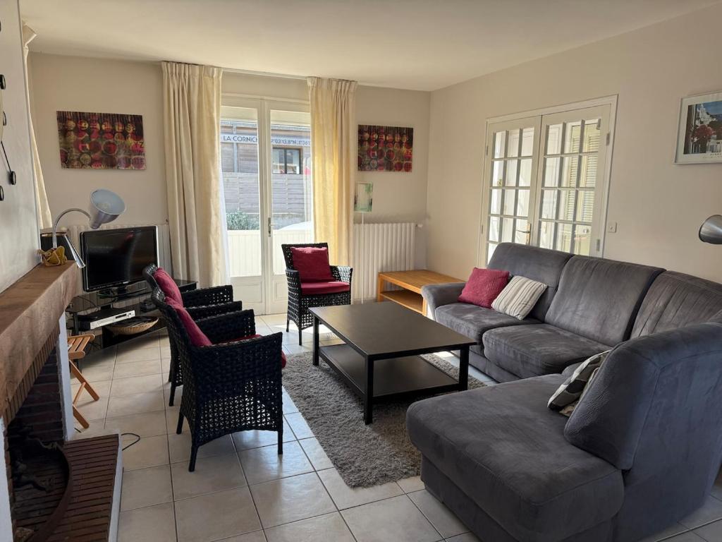 un salon avec un canapé et des chaises dans l'établissement La Corniche, à Agon-Coutainville