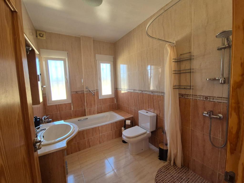 Un baño con bañera, inodoro y lavabo. en Casa Castillo, en Huércal-Overa