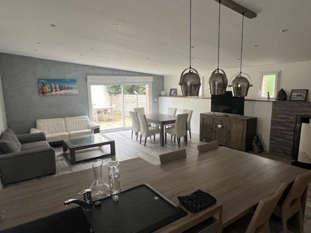 une cuisine et un salon avec une table et des chaises dans l'établissement Maison du manoir, à Bénouville