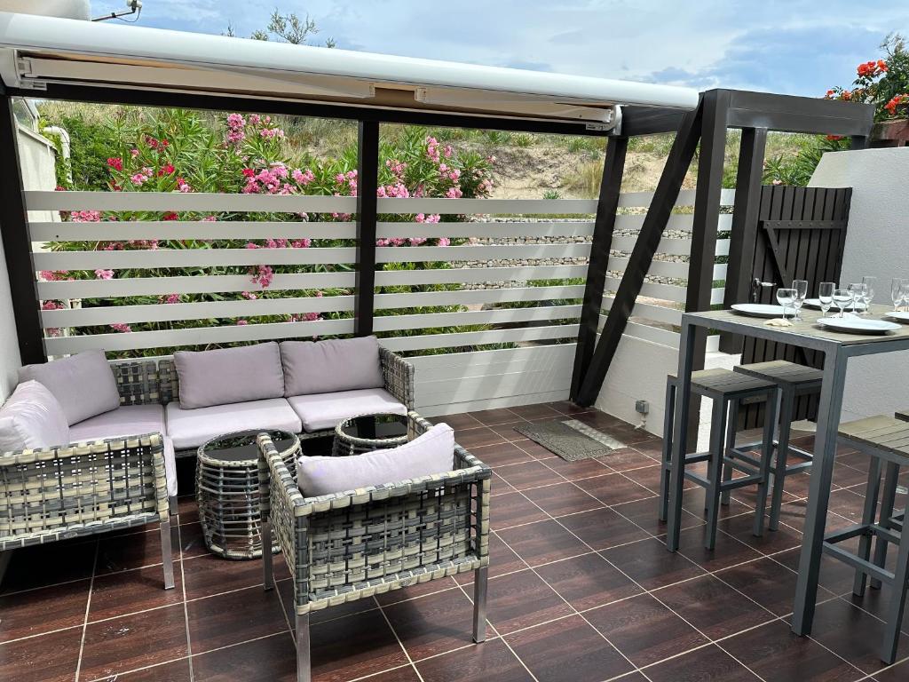 une véranda avec un canapé et une table dans l'établissement Villa n47 luxe Port Nature 1 Village Naturiste, au Cap d'Agde